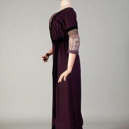 The 1912 purple wool and velvet dress on the custom mannequin from the side. This angle shows how the bust is prominent and raised.