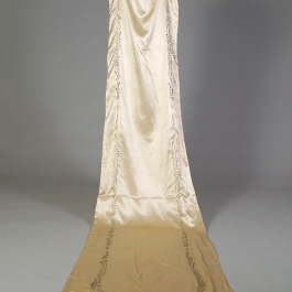 Back view of silk satin wedding dress showing the train embroidered in silk, KSUM 1983.1.334.