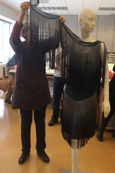 Robin Hanson, Textile Conservator at the Cleveland Museum of Art holds the band of fringe while she is in the process of taking the dress off the mannequin.